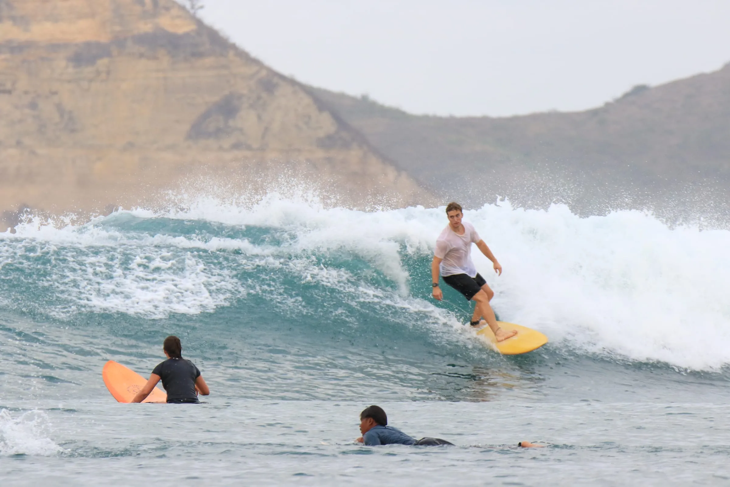 Felix surfing a right-hander on a yellow board