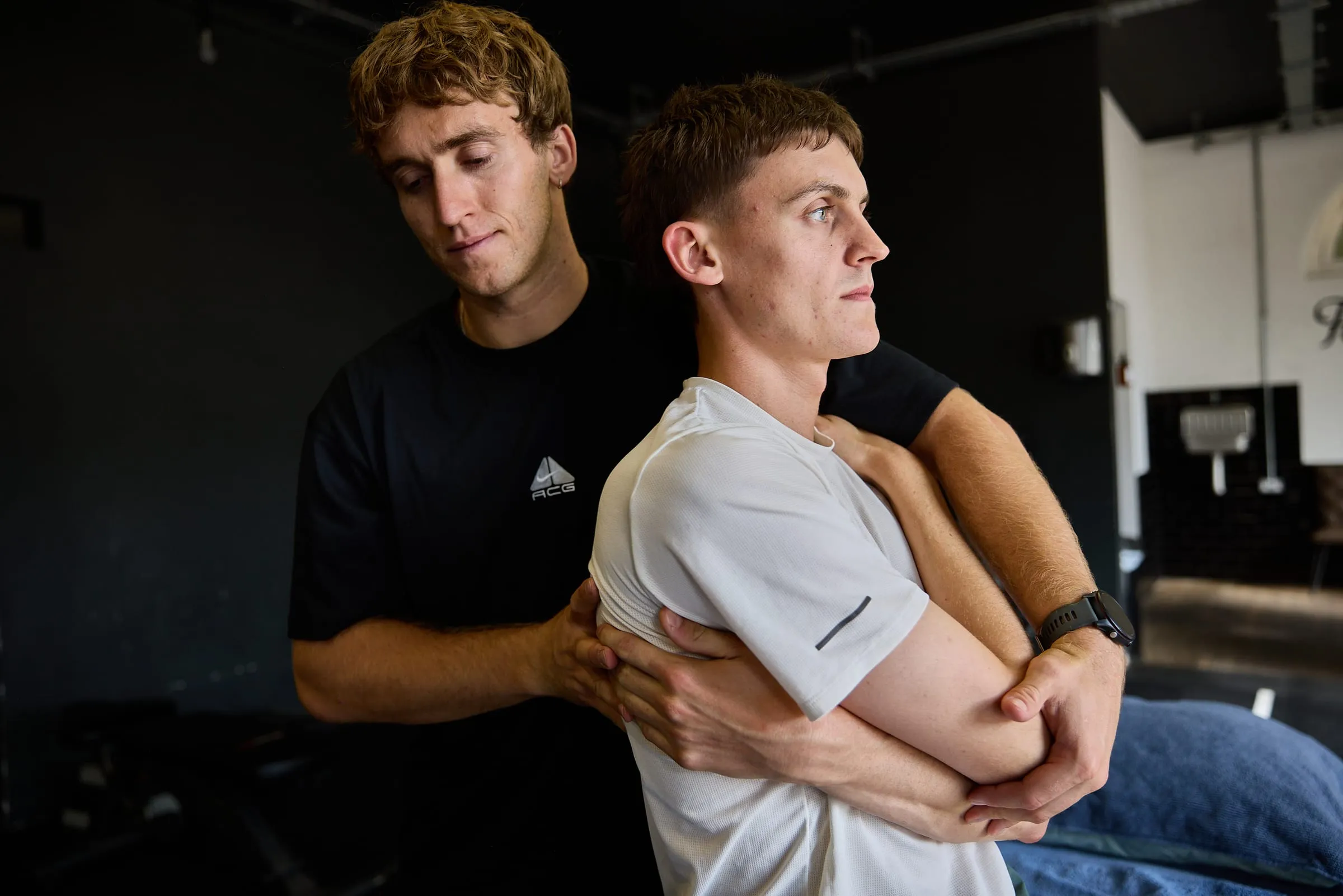 Felix applying a thoracic technique, arms wrapped around a seated client